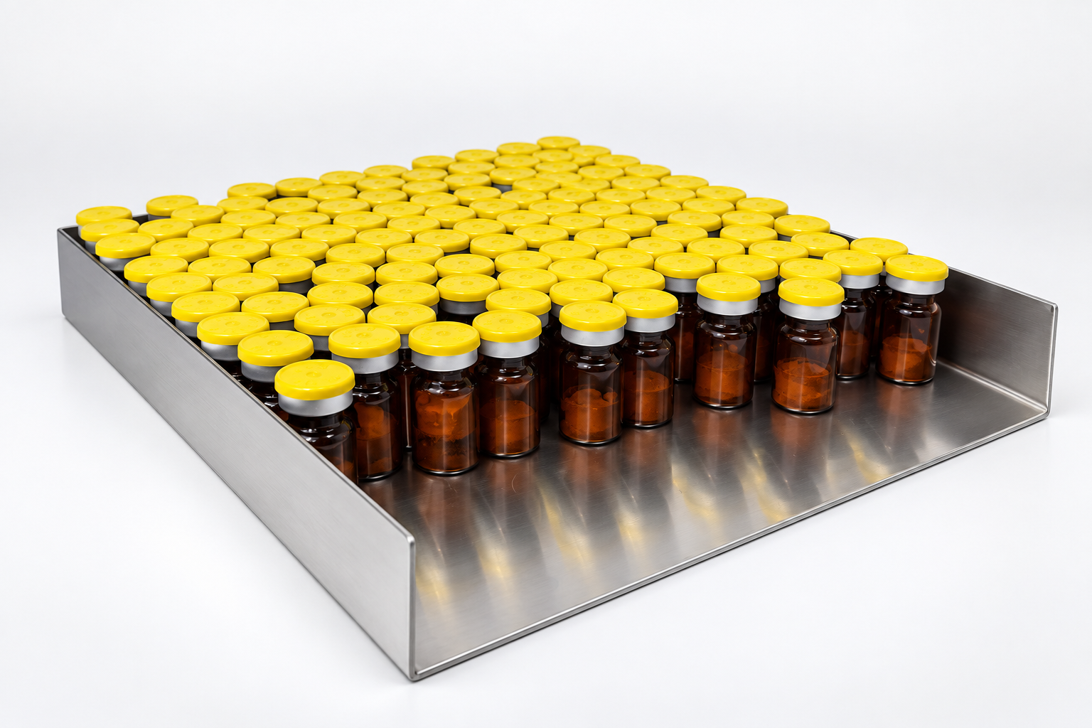 Rows of capped amber vials on a stainless steel loading tray